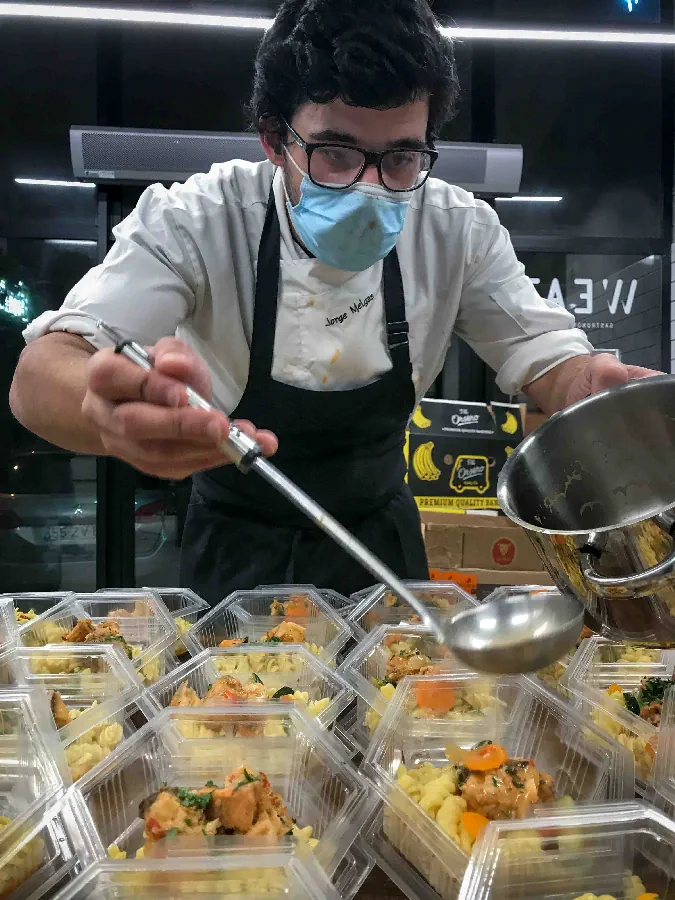 voluntario a preparar comida para doar hospitais