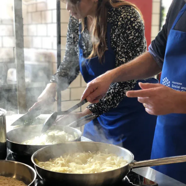 pessoas a cozinhar num teambuilding culinario